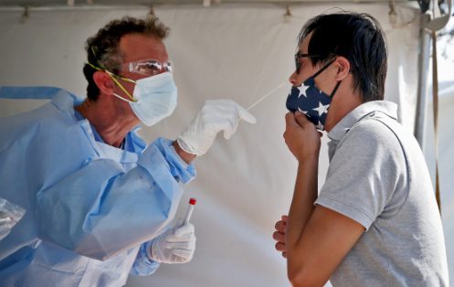 BOSTON MA. - AUGUST 5: Matthew Norcia, RN, performs a Covid test on Nick Le on Columbia Rd in Southie on August 5, 2020 in Boston, MA. (Staff Photo By Nancy Lane/MediaNews Group/Boston Herald)