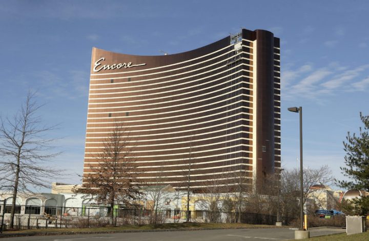 In this Wednesday, Jan. 2, 2019 photo the under-construction Encore Boston Harbor luxury resort and casino stands among smaller structures, in Everett, Mass. A Nevada judge was being asked Friday, Jan. 4 to let the Massachusetts Gaming Commission make public a report on allegations of sexual misconduct against former casino mogul Steve Wynn. A decision could affect a decision on a pending license for the $2 billion casino and hotel being built in Everett. (AP Photo/Steven Senne)