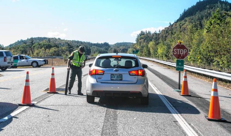 A U.S. Border Patrol agent checks a car on the I-93 southbound lane on Wednesday, September 28, 2017 south of the Route 175 exit south of Lincoln.